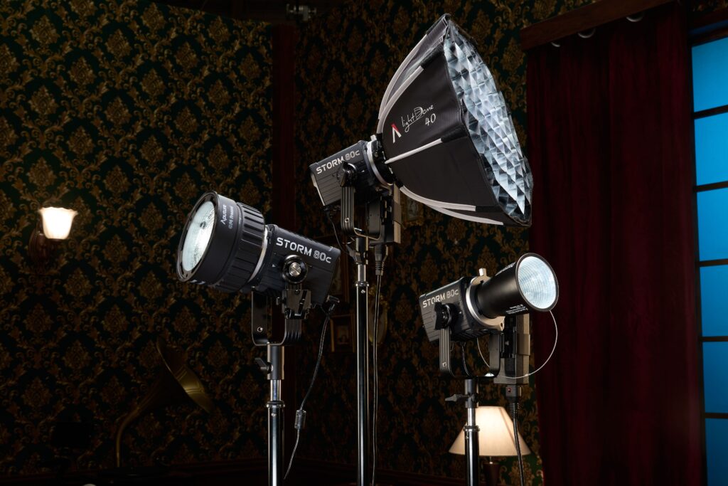 Three Aputure Storm 80c lights with modifiers in a studio.