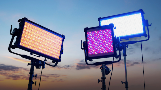 AputureNOVA 9° 2×1 and the NOVA II 1×1 LED panels on studio stands, displaying different color temperatures and RGB effects against a sunset sky.