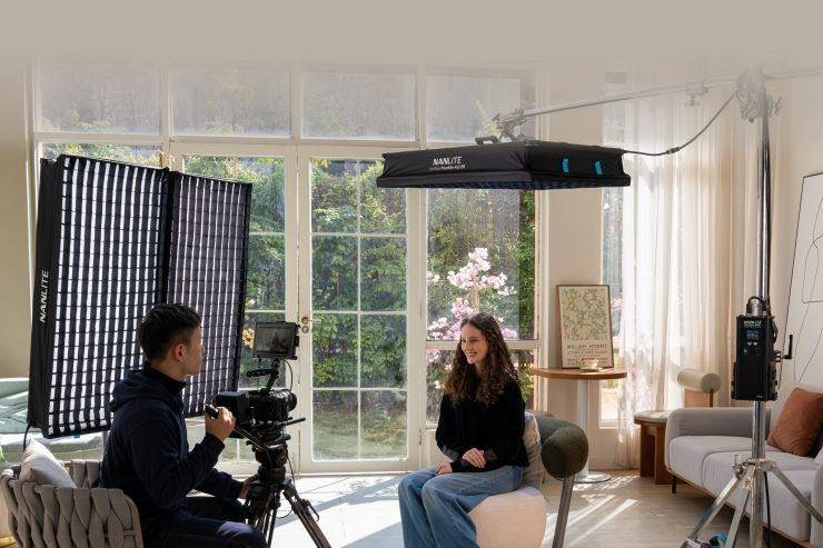 Nanlite LED studio lights and softboxes being used by a camera operator to film a seated interview subject