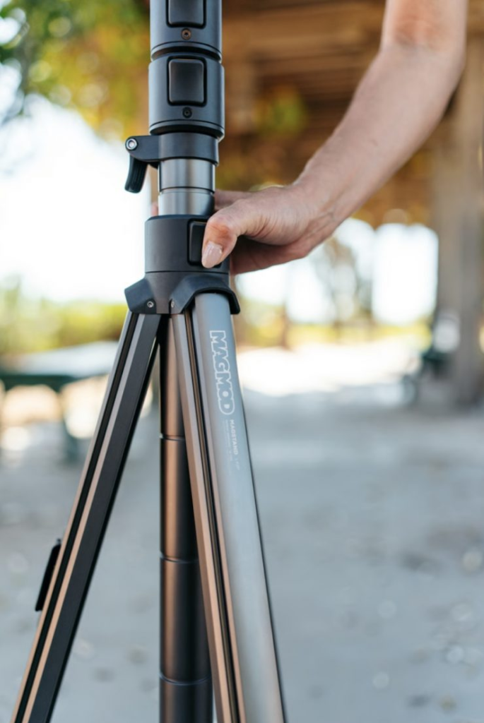 The MagMod MagStand being deployed on location, showing the easy-to-use auto-lock extension buttons